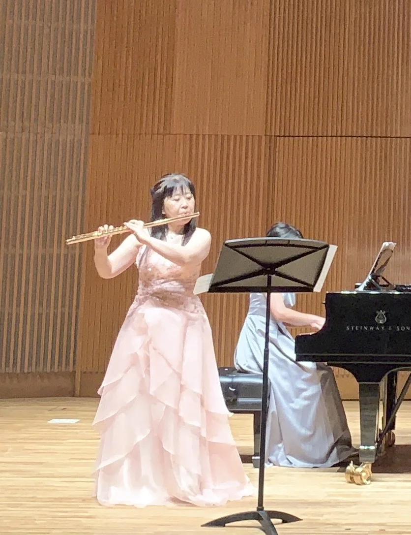 ホールでフルートとピアノを演奏する山崎孝子と共演者